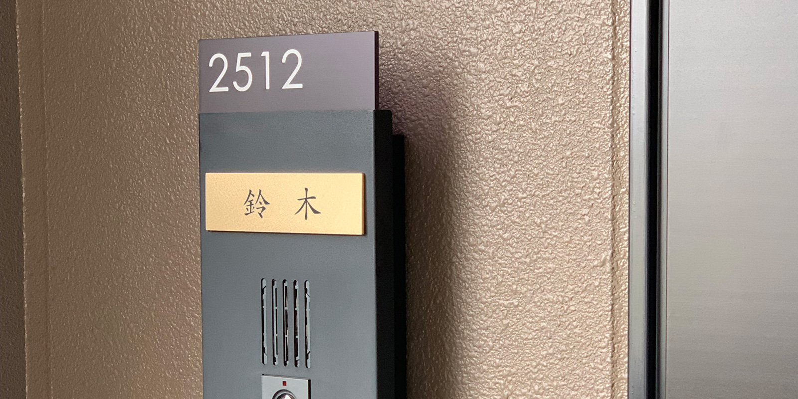 マンションユニットにマグネットで貼り付けた真鍮表札